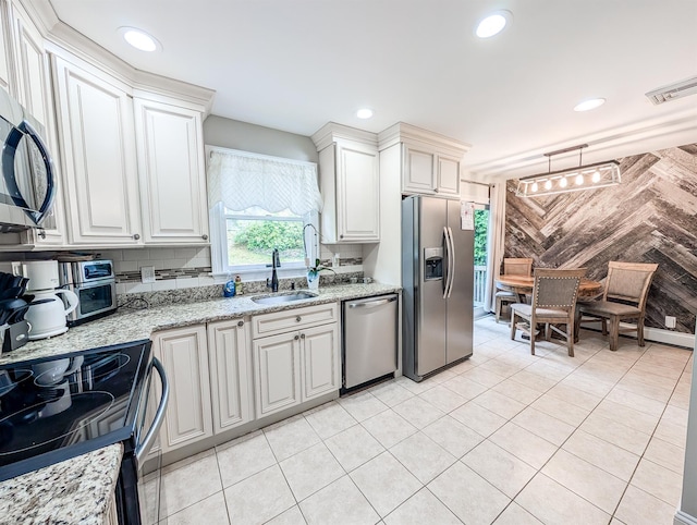 14 Hampton Rd, Sound Beach, NY 11789 - kitchen with appliances with stainless steel finishes, recessed lighting, white cabinets, light tile patterned flooring, and wood walls