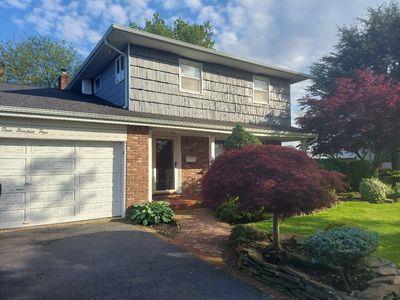 404 Club Ct, Oceanside, NY 11572 - traditional-style home with asphalt driveway, a garage, and brick siding