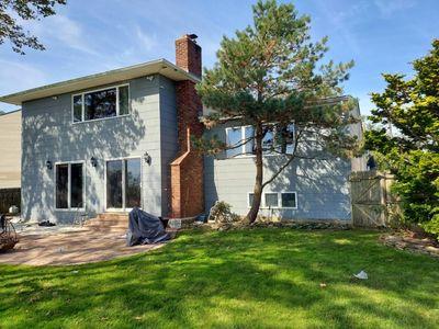 404 Club Ct, Oceanside, NY 11572 - rear view of house featuring a yard, a chimney, a patio area, and a gate