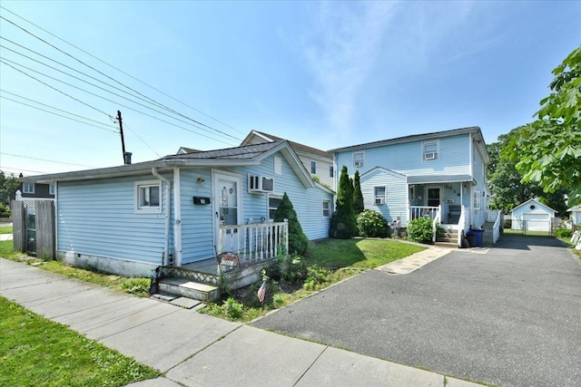 218 Mott St, Oceanside, NY 11572 - multi unit property with driveway, covered porch, an outbuilding, a detached garage, and a front lawn