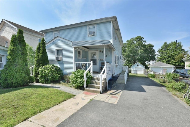 218 Mott St, Oceanside, NY 11572 - view of front of home with a porch, a front yard, asphalt driveway, and a detached garage