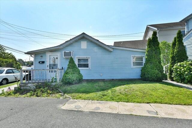 218 Mott St, Oceanside, NY 11572 - view of front of house with a front lawn and an AC wall unit
