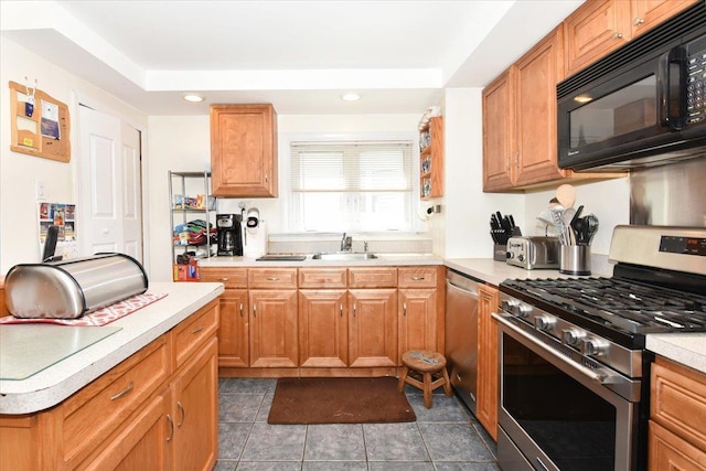 218 Mott St, Oceanside, NY 11572 - kitchen with stainless steel appliances, light countertops, a tray ceiling, dark tile patterned flooring, and recessed lighting