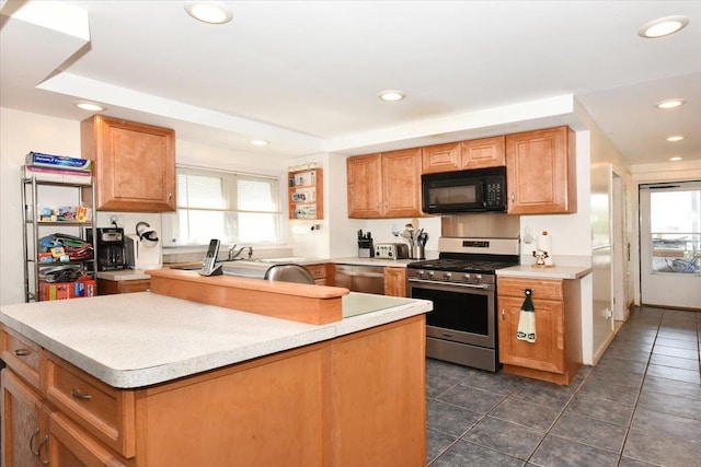 218 Mott St, Oceanside, NY 11572 - kitchen featuring appliances with stainless steel finishes, a center island, recessed lighting, dark tile patterned flooring, and light countertops