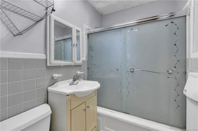 51 White Oak St Unit 2A, New Rochelle, NY 10801 - bathroom with vanity, tile walls, shower / bath combination with glass door, and decorative backsplash