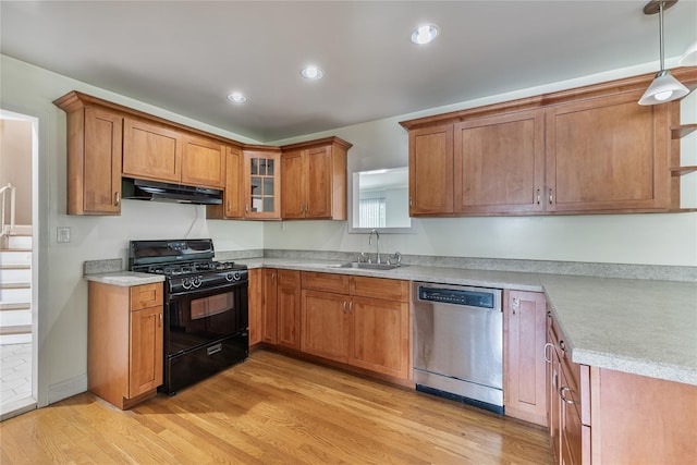 10 Salem Ct, Spring Valley, NY 10977 - kitchen with black range with gas cooktop, stainless steel dishwasher, under cabinet range hood, light wood-style floors, and brown cabinets