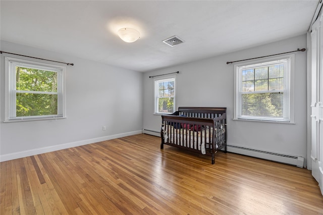 10 Salem Ct, Spring Valley, NY 10977 - bedroom featuring baseboard heating and light wood-type flooring