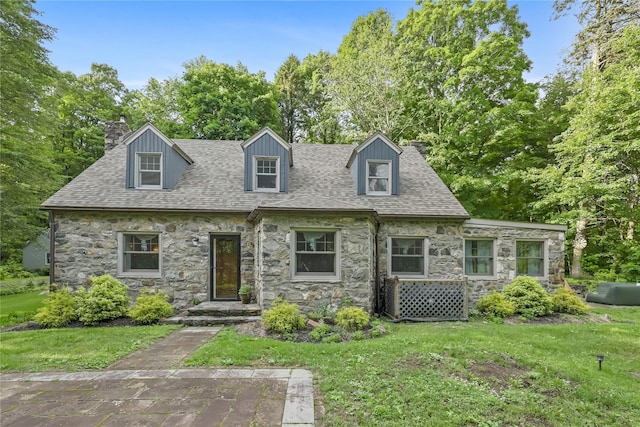 210 Foggintown Rd, Brewster, NY 10509 - cape cod-style house featuring stone siding, a chimney, a front yard, and roof with shingles