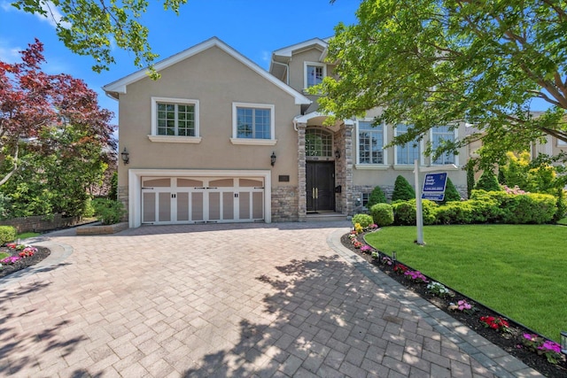 760 Hillcrest Pl, North Woodmere, NY 11581 - traditional-style home featuring stone siding, stucco siding, an attached garage, decorative driveway, and a front lawn