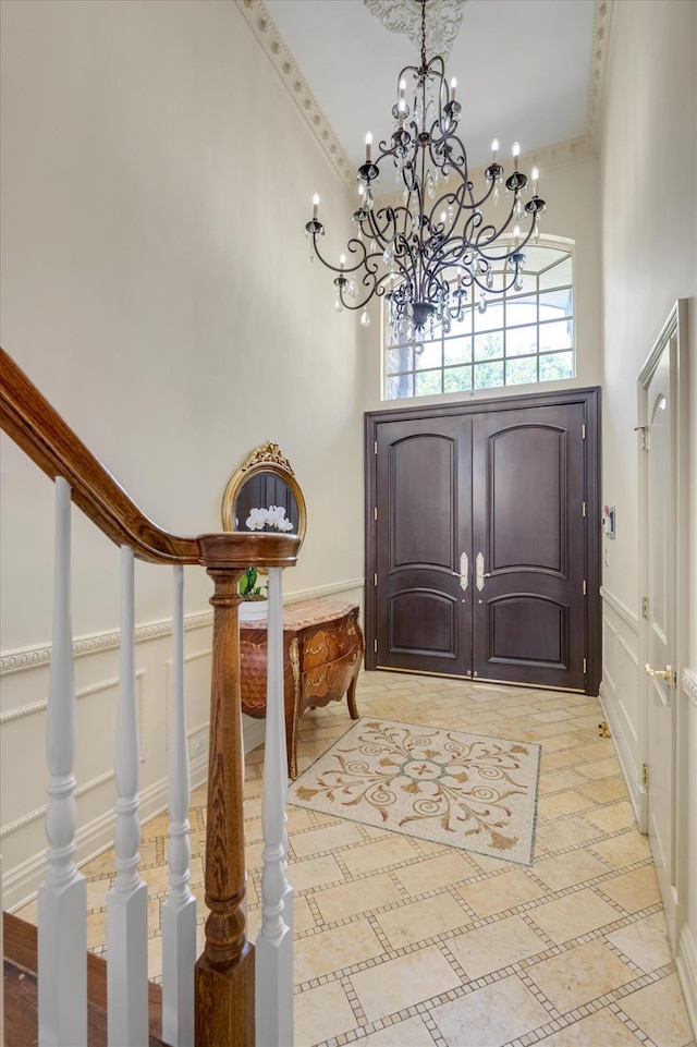 760 Hillcrest Pl, North Woodmere, NY 11581 - entryway featuring a chandelier, a decorative wall, a towering ceiling, wainscoting, and ornamental molding