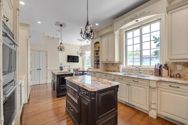 760 Hillcrest Pl, North Woodmere, NY 11581 - kitchen with stainless steel microwave, a chandelier, healthy amount of natural light, decorative backsplash, and recessed lighting