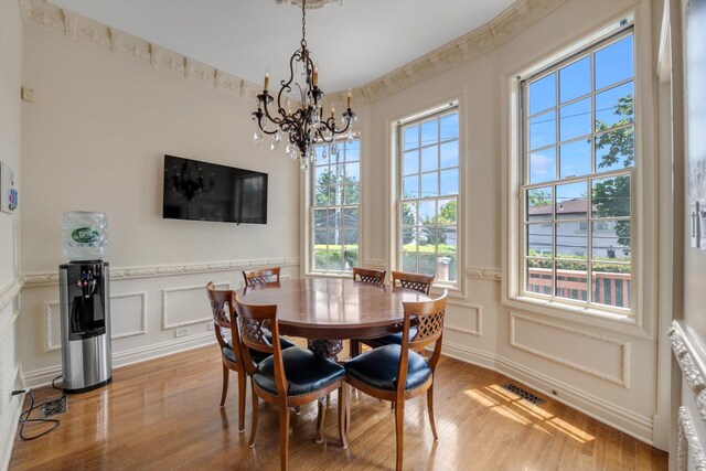 760 Hillcrest Pl, North Woodmere, NY 11581 - dining space featuring a chandelier, light wood-style floors, plenty of natural light, a decorative wall, and wainscoting