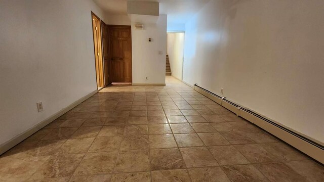 222 Capstan Ct Unit 101B, College Point, NY 11356 - unfurnished room featuring a baseboard heating unit and stairs