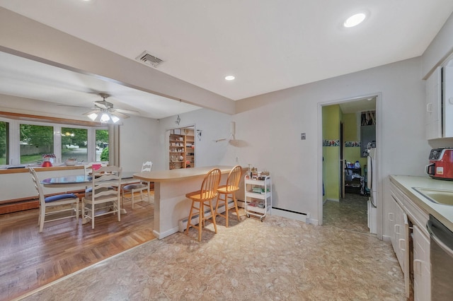 8 Peconic Ln, Selden, NY 11784 - kitchen with dishwasher, a kitchen bar, a baseboard heating unit, a ceiling fan, and light countertops