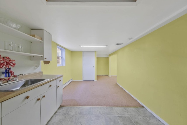 8 Peconic Ln, Selden, NY 11784 - kitchen with open shelves, white cabinetry, baseboard heating, light carpet, and light countertops