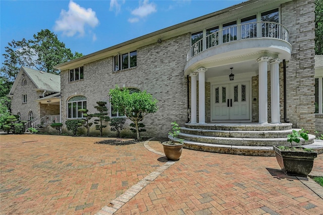 1537 Laurel Hollow Rd, Laurel Hollow, NY 11791 - view of front facade with a balcony, french doors, and brick siding