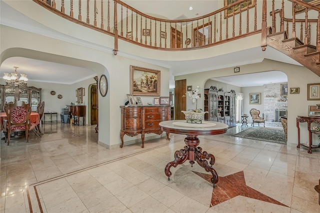 1537 Laurel Hollow Rd, Laurel Hollow, NY 11791 - entryway featuring arched walkways, a chandelier, a towering ceiling, ornamental molding, and stairs