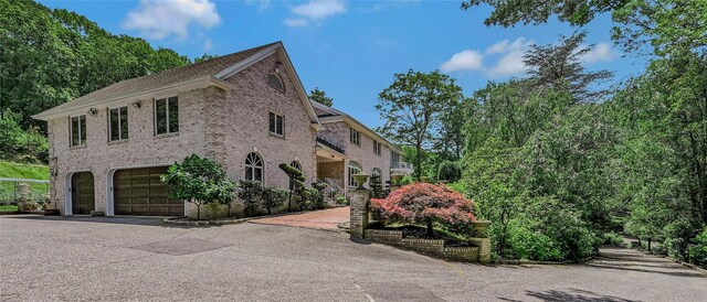 1537 Laurel Hollow Rd, Laurel Hollow, NY 11791 - view of front of house with brick siding, a garage, and driveway