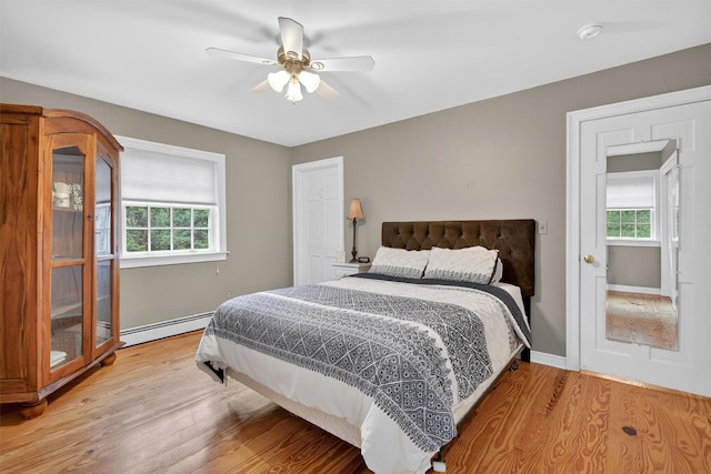 114 Bulsontown Rd, Stony Point, NY 10980 - bedroom featuring a baseboard heating unit, multiple windows, wood finished floors, and a ceiling fan