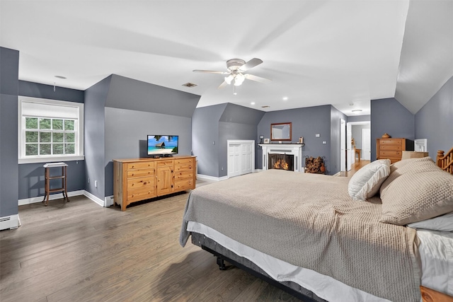 114 Bulsontown Rd, Stony Point, NY 10980 - bedroom featuring light wood finished floors, lofted ceiling, a warm lit fireplace, a ceiling fan, and a baseboard heating unit