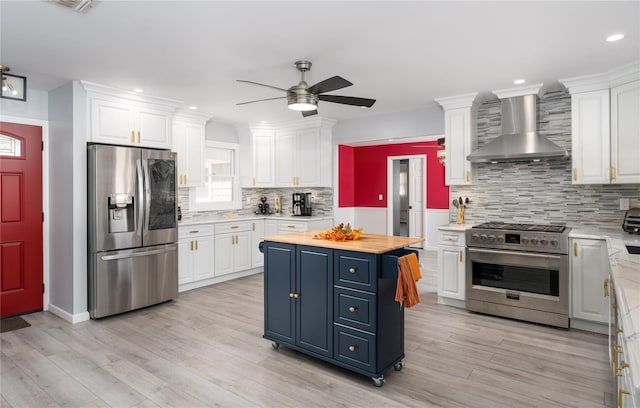 25 Segatogue Ln, South Setauket, NY 11720 - kitchen with stainless steel appliances, wall chimney range hood, white cabinetry, and recessed lighting