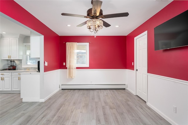 25 Segatogue Ln, South Setauket, NY 11720 - unfurnished dining area featuring baseboard heating, ceiling fan, wainscoting, light wood-type flooring, and recessed lighting