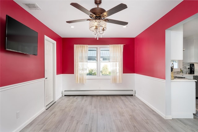 25 Segatogue Ln, South Setauket, NY 11720 - unfurnished dining area with baseboard heating, a ceiling fan, and light wood finished floors