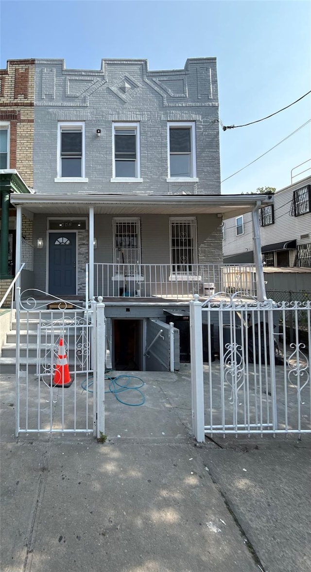 442 Newport St, Brooklyn, NY 11207 - townhome / multi-family property featuring a porch, a fenced front yard, and brick siding