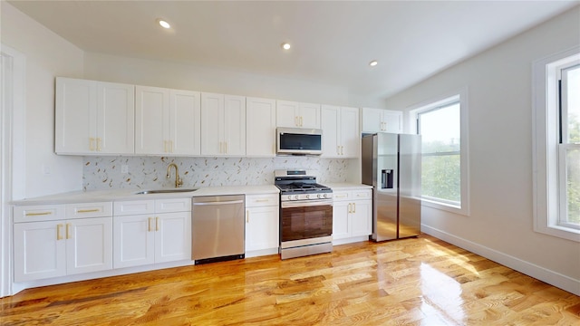 442 Newport St, Brooklyn, NY 11207 - kitchen featuring stainless steel appliances, backsplash, white cabinets, light countertops, and light wood finished floors