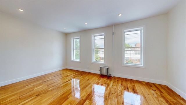 442 Newport St, Brooklyn, NY 11207 - empty room with radiator heating unit, light wood finished floors, and recessed lighting
