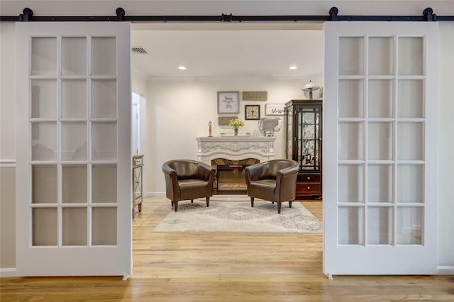 1241 Lednam Ct, Merrick, NY 11566 - living area with a barn door, wood finished floors, and recessed lighting