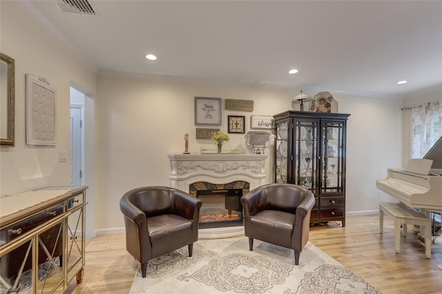 1241 Lednam Ct, Merrick, NY 11566 - sitting room with light wood-style flooring, ornamental molding, recessed lighting, and a glass covered fireplace