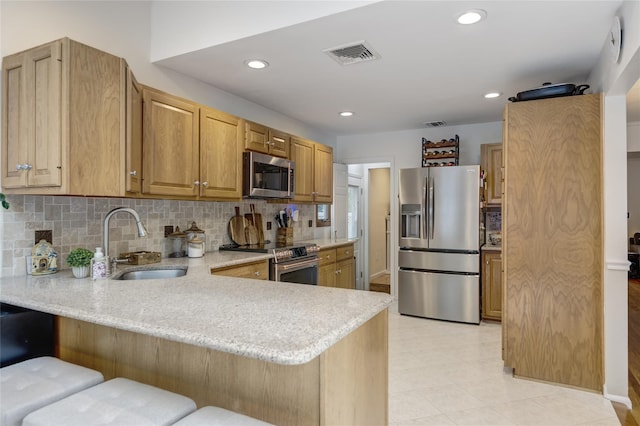 1241 Lednam Ct, Merrick, NY 11566 - kitchen with appliances with stainless steel finishes, a peninsula, backsplash, a kitchen breakfast bar, and light stone countertops