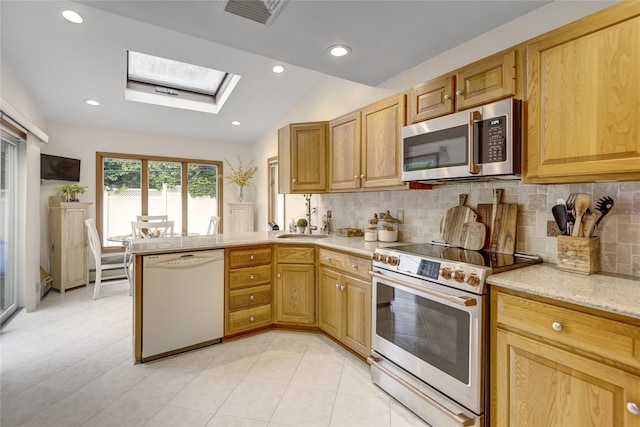 1241 Lednam Ct, Merrick, NY 11566 - kitchen featuring appliances with stainless steel finishes, a skylight, lofted ceiling, backsplash, and a peninsula