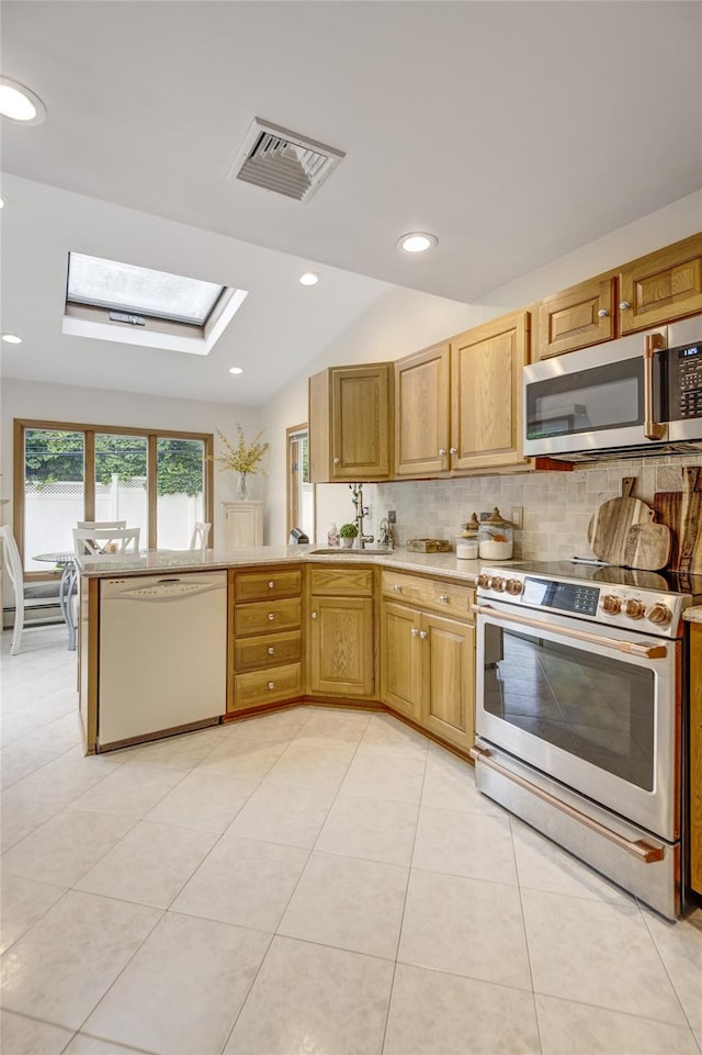 1241 Lednam Ct, Merrick, NY 11566 - kitchen with appliances with stainless steel finishes, backsplash, a skylight, light tile patterned floors, and a peninsula