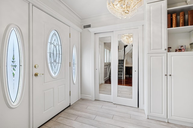57 Sarah Dr, Lake Grove, NY 11755 - foyer entrance with a chandelier, plenty of natural light, ornamental molding, and light wood-type flooring
