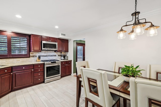 57 Sarah Dr, Lake Grove, NY 11755 - kitchen featuring stainless steel appliances, dark brown cabinets, backsplash, ornamental molding, and decorative light fixtures