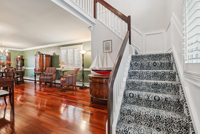 57 Sarah Dr, Lake Grove, NY 11755 - stairs featuring hardwood / wood-style floors, a chandelier, ornamental molding, a decorative wall, and a baseboard heating unit