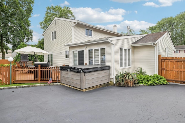 57 Sarah Dr, Lake Grove, NY 11755 - back of property featuring a hot tub, a patio, a chimney, and a wooden deck