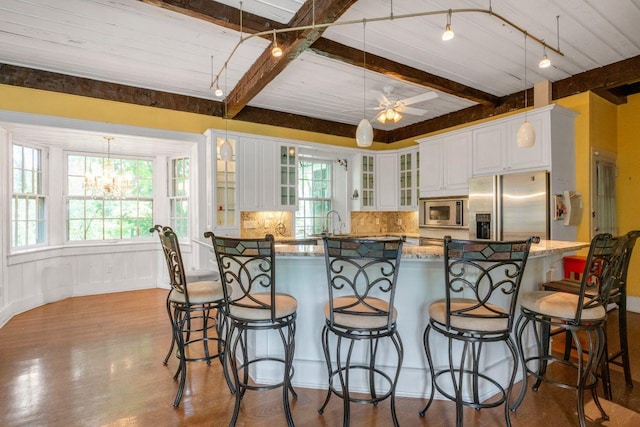 23 Gracemere, Tarrytown, NY 10591 - kitchen with stainless steel appliances, beamed ceiling, decorative backsplash, white cabinets, and glass insert cabinets