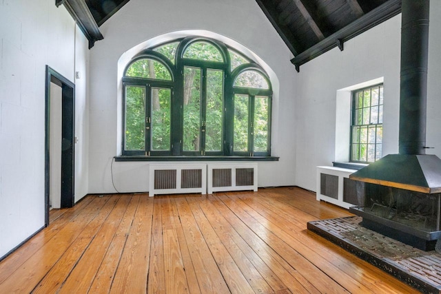 23 Gracemere, Tarrytown, NY 10591 - entrance foyer featuring a wood stove, radiator, high vaulted ceiling, wood-type flooring, and beamed ceiling
