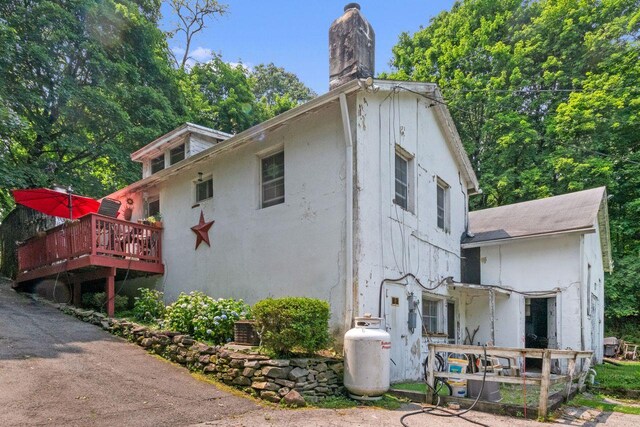 23 Gracemere, Tarrytown, NY 10591 - view of side of property featuring a chimney, a deck, and stucco siding