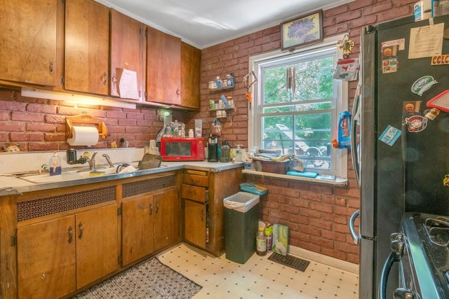 23 Gracemere, Tarrytown, NY 10591 - kitchen with stainless steel appliances, brick wall, light floors, brown cabinets, and light countertops