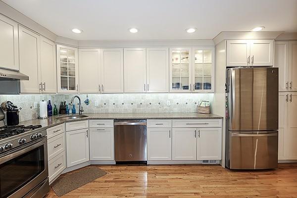 183 Atlantic Ave Unit 8, Lynbrook, NY 11563 - kitchen with appliances with stainless steel finishes, white cabinetry, stone countertops, backsplash, and recessed lighting