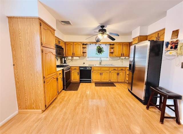 945 Swinton Ave, Bronx, NY 10465 - kitchen with black appliances, open shelves, light wood finished floors, light countertops, and brown cabinetry