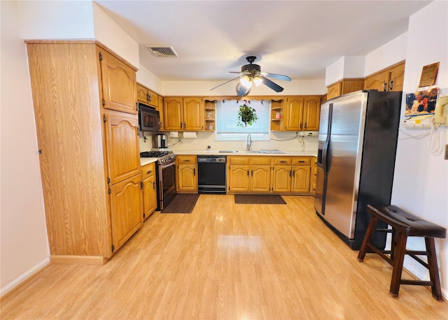 945 Swinton Ave, Bronx, NY 10465 - kitchen with black appliances, open shelves, light countertops, and light wood-style flooring