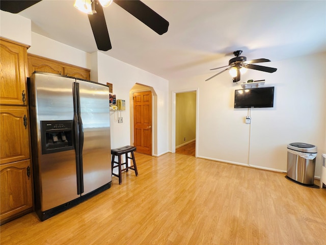 945 Swinton Ave, Bronx, NY 10465 - kitchen featuring stainless steel fridge, ceiling fan, light wood finished floors, arched walkways, and brown cabinets
