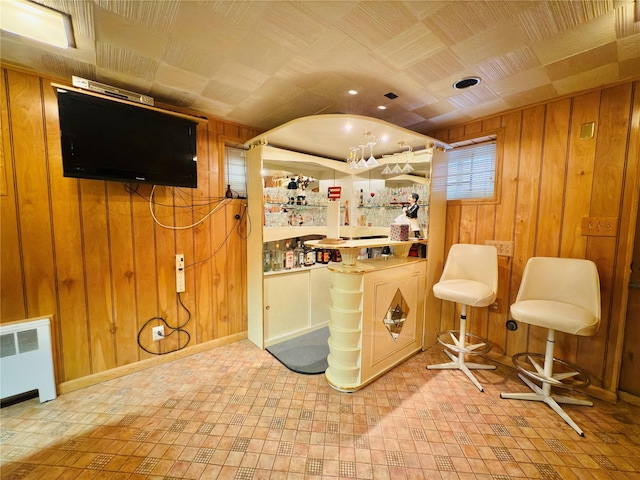 945 Swinton Ave, Bronx, NY 10465 - indoor dry bar with wooden walls, radiator heating unit, and tile patterned floors