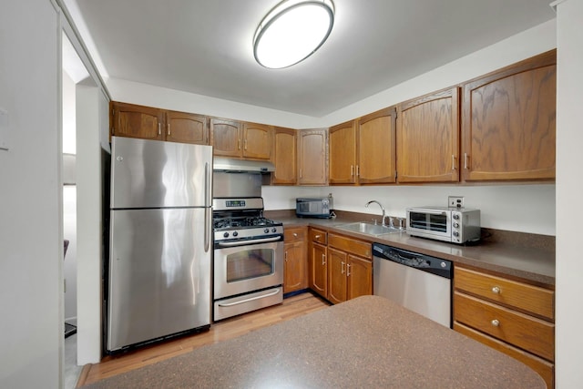 12 Scenic Dr Unit K, Croton-On-Hudson, NY 10520 - kitchen featuring stainless steel appliances, dark countertops, light wood finished floors, and under cabinet range hood