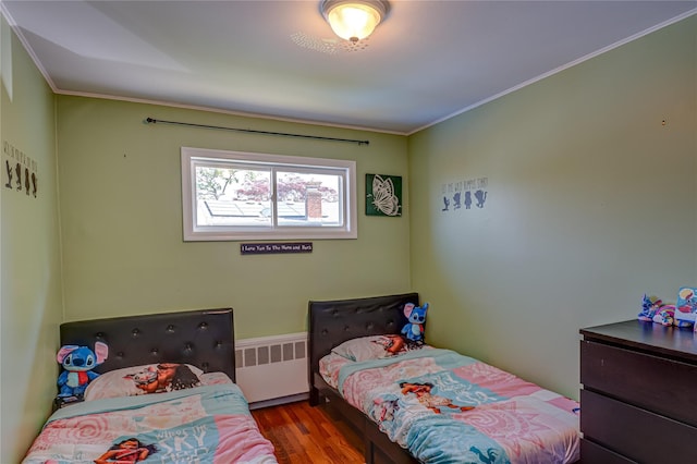 17 Abbott St, West Babylon, NY 11704 - bedroom featuring radiator heating unit, wood finished floors, and crown molding